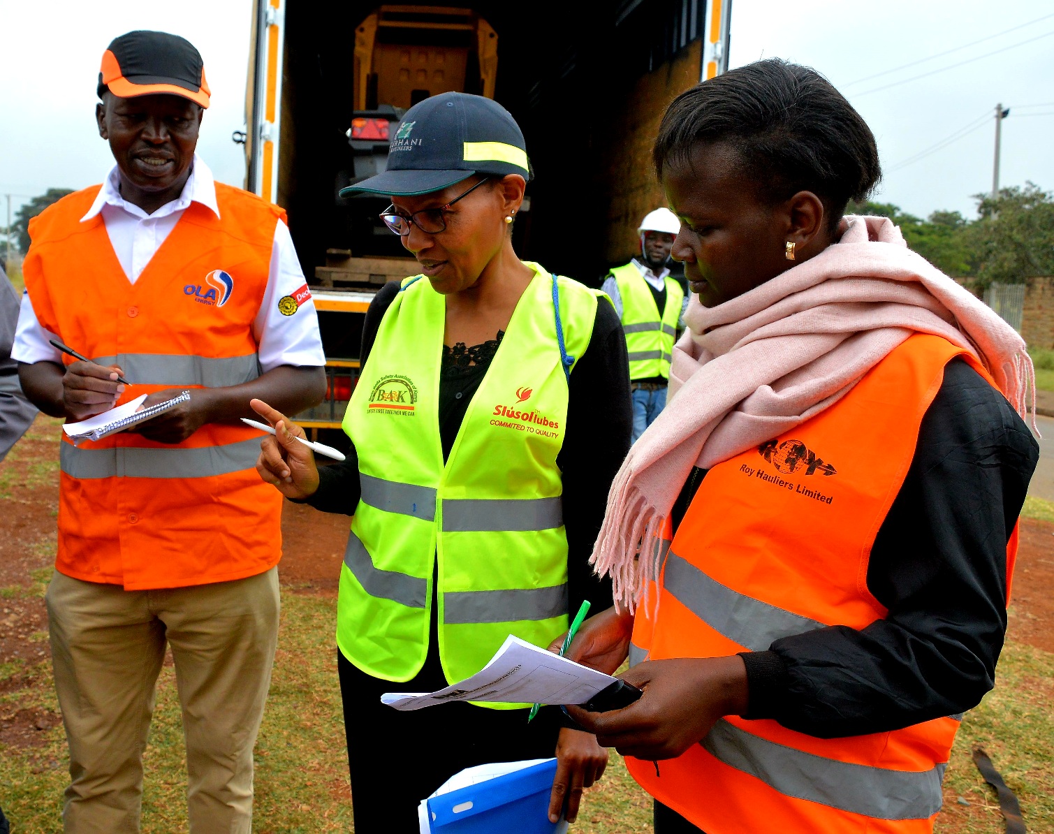 OLA Energy Kenya Safety, Health and Environment Manager, Ernest Changwony, Petroleum Institute of East Africa General Manager Wanjiku Manyara and Roy Hauliers Safety Manager Mercy Nerima compare notes during a highway emergency response drill carried out in Nairobi to test and evaluate emergency response-ability.