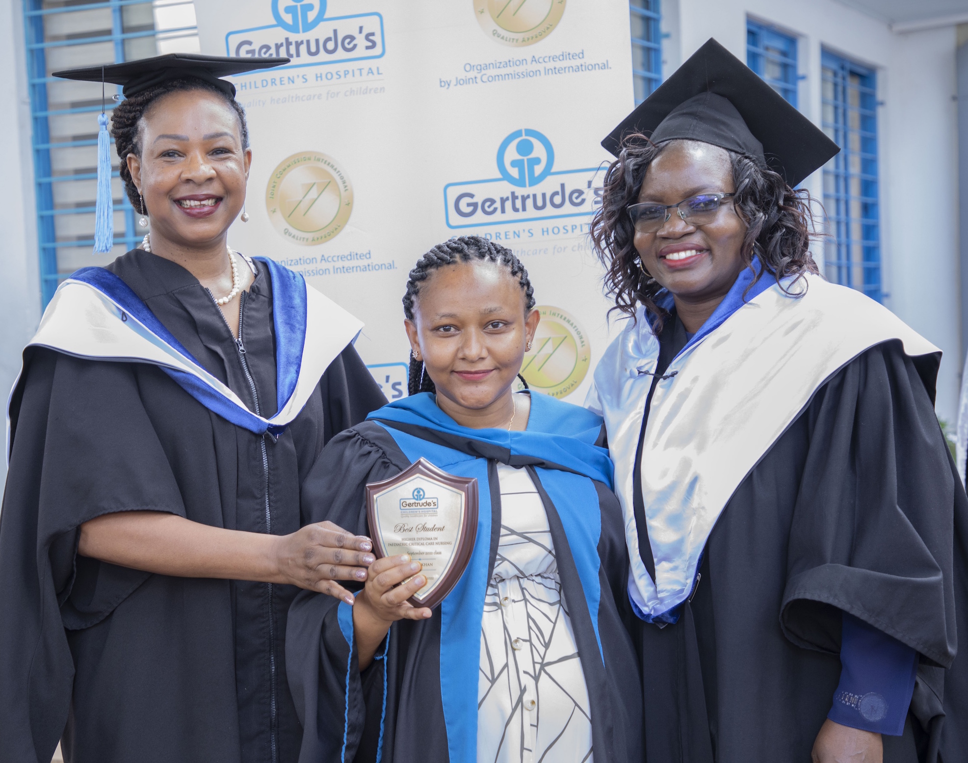 Gertrude's Hospital trustee, Prof. Elizabeth Obimbo (left), presents Khan Nasra Ismail with the best student award in Higher National Diploma in Kenya Registered Paediatric Critical Care Nursing, class of September 2022. Looking on is Gertrude’s Institute of Child Health and Research Principal Perez Obonyo.
