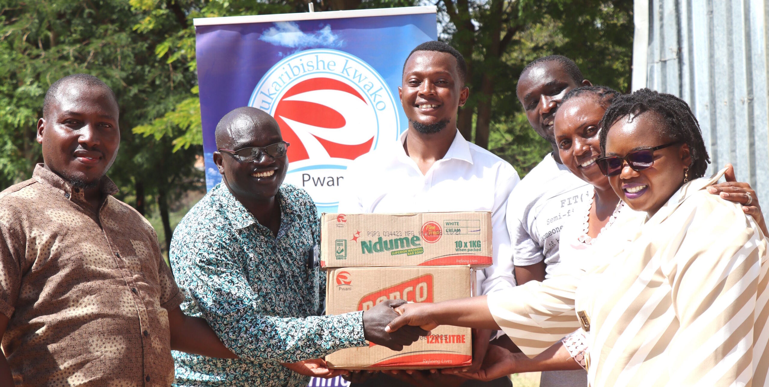 Pwani Oil’s Central Team Lead, Susan Njeru Mungai (Far Right), hands over a donation of cooking oil and personal care items, including boxes of bar soap, to Isiolo North constituency representatives. The donation aims to assist at least 1,000 families affected by recent floods.