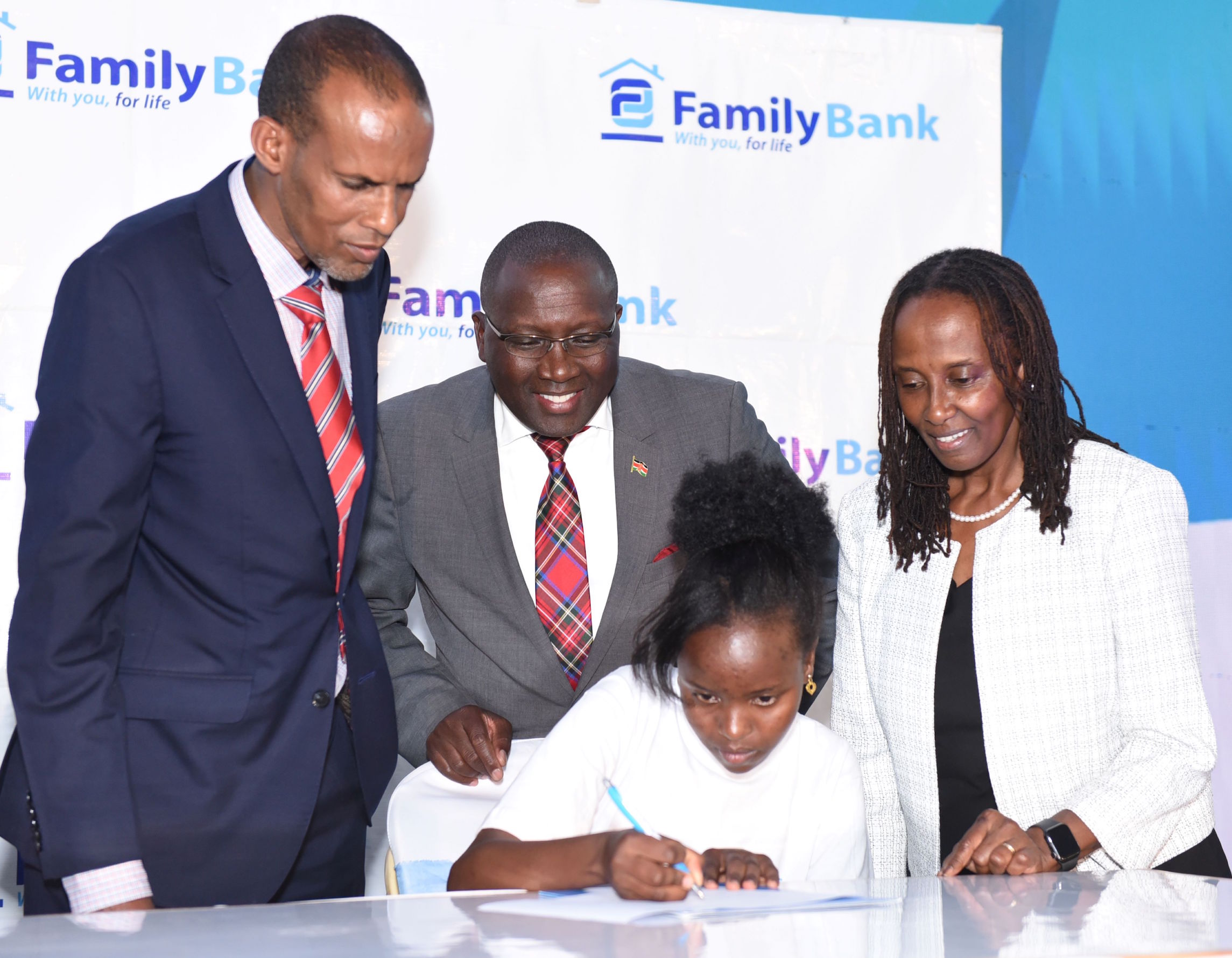 Ministry of Education Director General Elyas Abdi, The Family Group Foundation Chair Dr. Francis Muraya, Military Wives Association of Kenya Chair Aileen Ogolla join Ann Wambui one of the 352 beneficiaries during the 2024 commissioning of the KES. 90 million High School Scholarship Programme. 