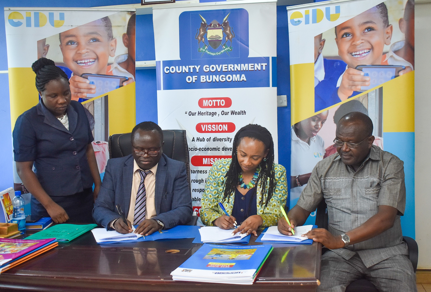 Dr. David Wanyonyi Bungoma CECM for Education and Vocational Training (second left) and EIDU Head of Government Relations, Salome Mwaura (second right) sign a contract to begin the implementation of EIDU’s digital learning program targeting over 3,000 learners from 36 Early Childhood Development and Education (ECDE) centres across the county. They are flanked by Abigael Walaka, Legal Officer, County Attorney office (left) and Nicholas Misoi, Chief Officer-Education. Over 230,000 learners from seven counties across Kenya are already using the program.