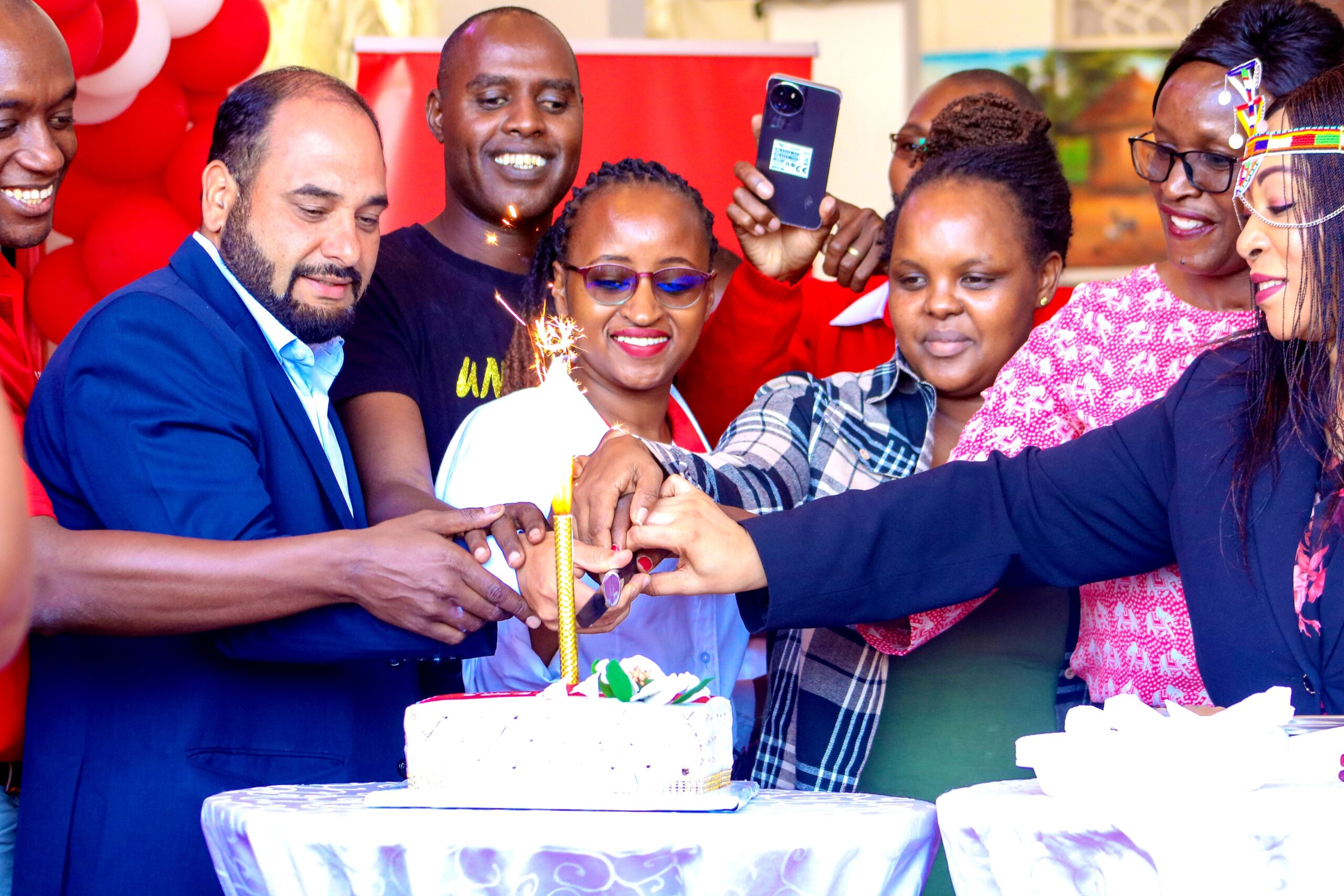 Airtel Kenya MD Ashish Malhotra leads team in cake cutting during the launch of Airtel Customer Care shop in Maralal town.