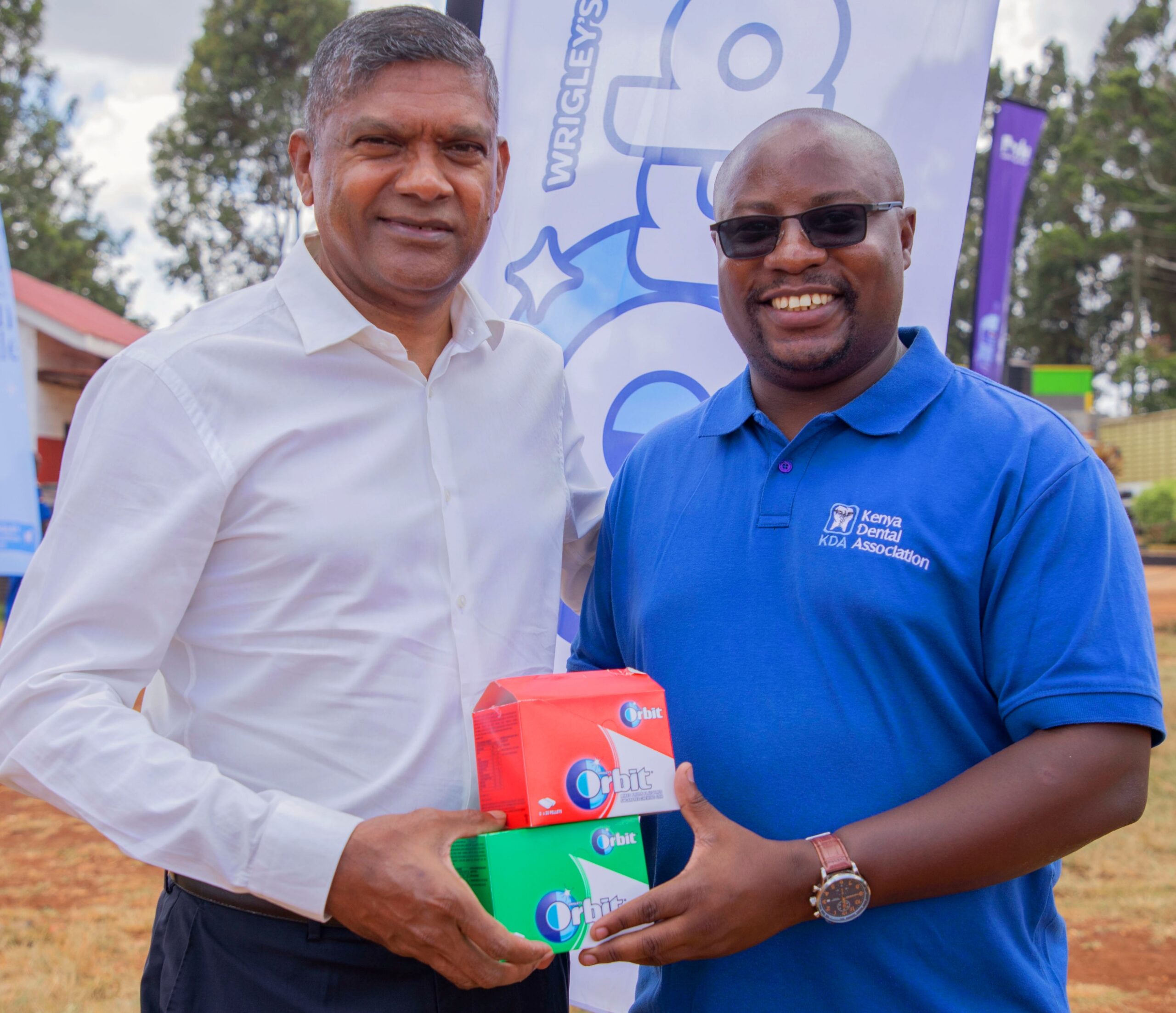 Vivian Maduray, Plant Director Mars Wrigley (left) presents sugar free gum to Dr. Douglas Oramis- Secretary General Kenya Dental Association (KDA) during the World Oral Health day celebrations held in Kiambu County. KDA unveiled its first cohort of 400 Community Health Promoters (CHPs), who completed training in basic preventive and promotive oral health support. The graduates were issued with certificates during the celebration to mark the World Oral Health Day at Ndumberi Stadium in Kiambu county.